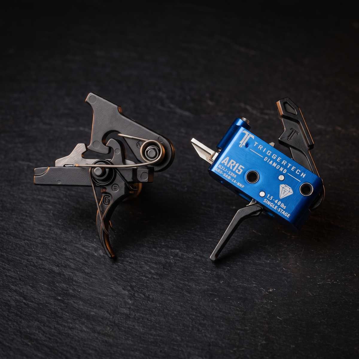Geissele and TriggerTech drop-in AR-15 triggers side by side, accompanying our comparison of AR trigger brands