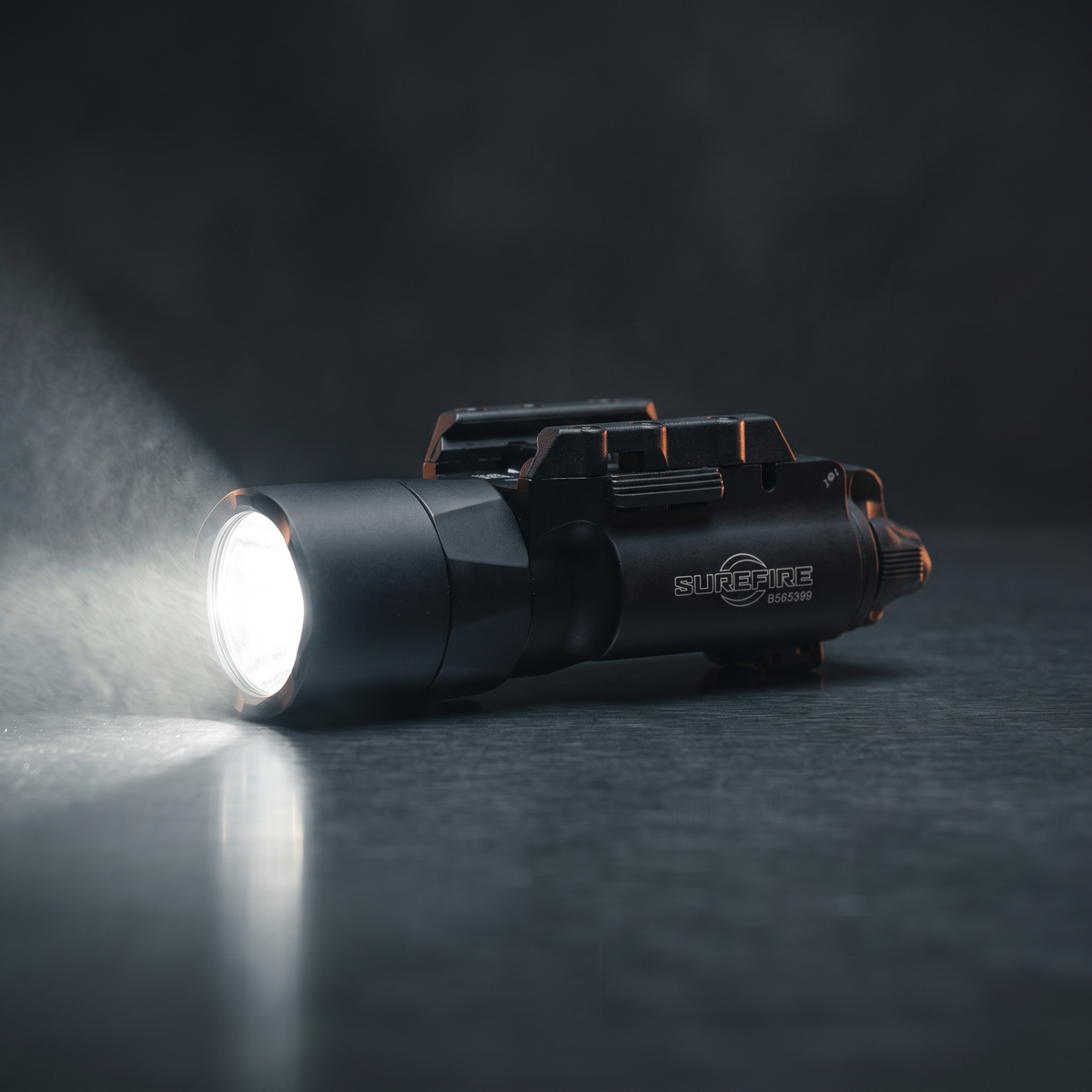 SureFire X300T-B Turbo weapon light switched on in a dark studio, illustrating our guide to choosing a weapon light