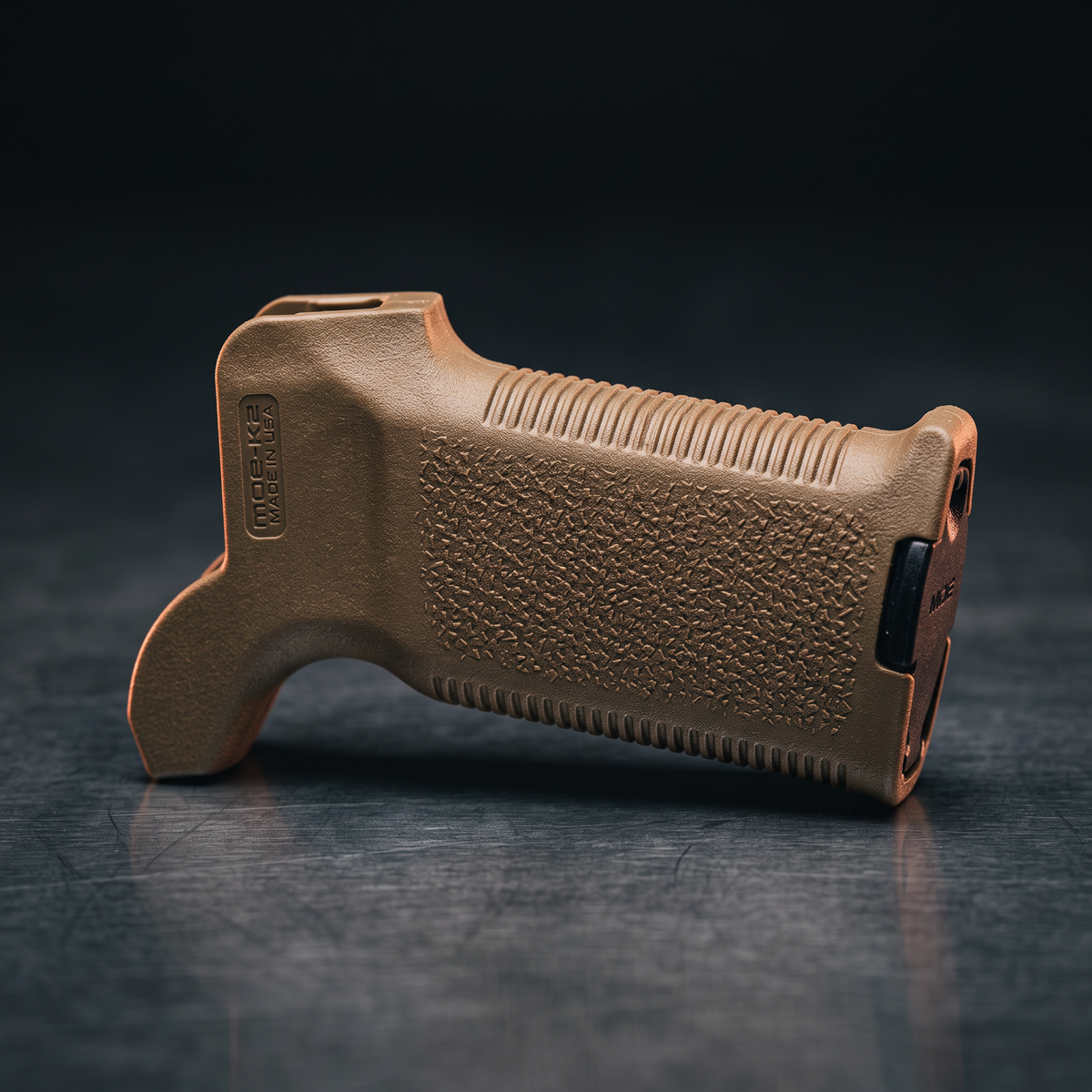 Gun Grips & Foregrips – Magpul MOE-K2 pistol grip in coyote brown on a dark steel surface