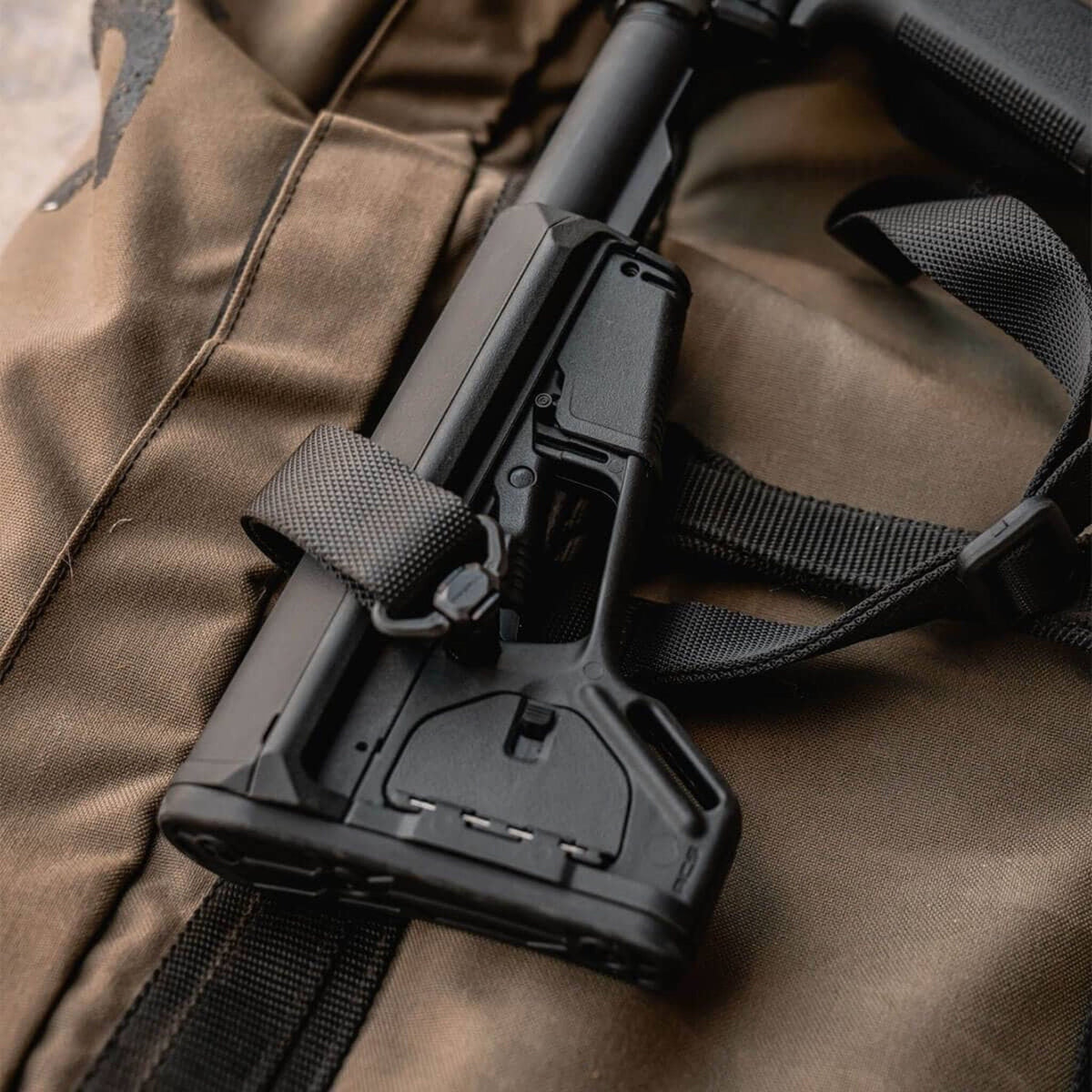 Magpul ACS-L Carbine Stock Mil-Spec for AR-15/M4, on a rifle resting on a kit bag