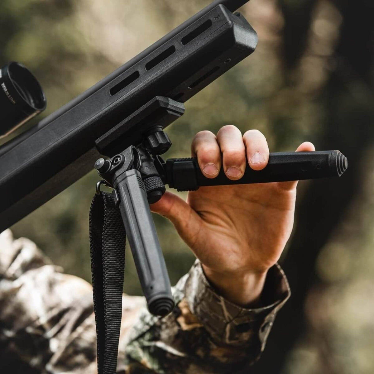 Magpul Bipod for Sling Stud QD, in use, legs being adjusted by hand